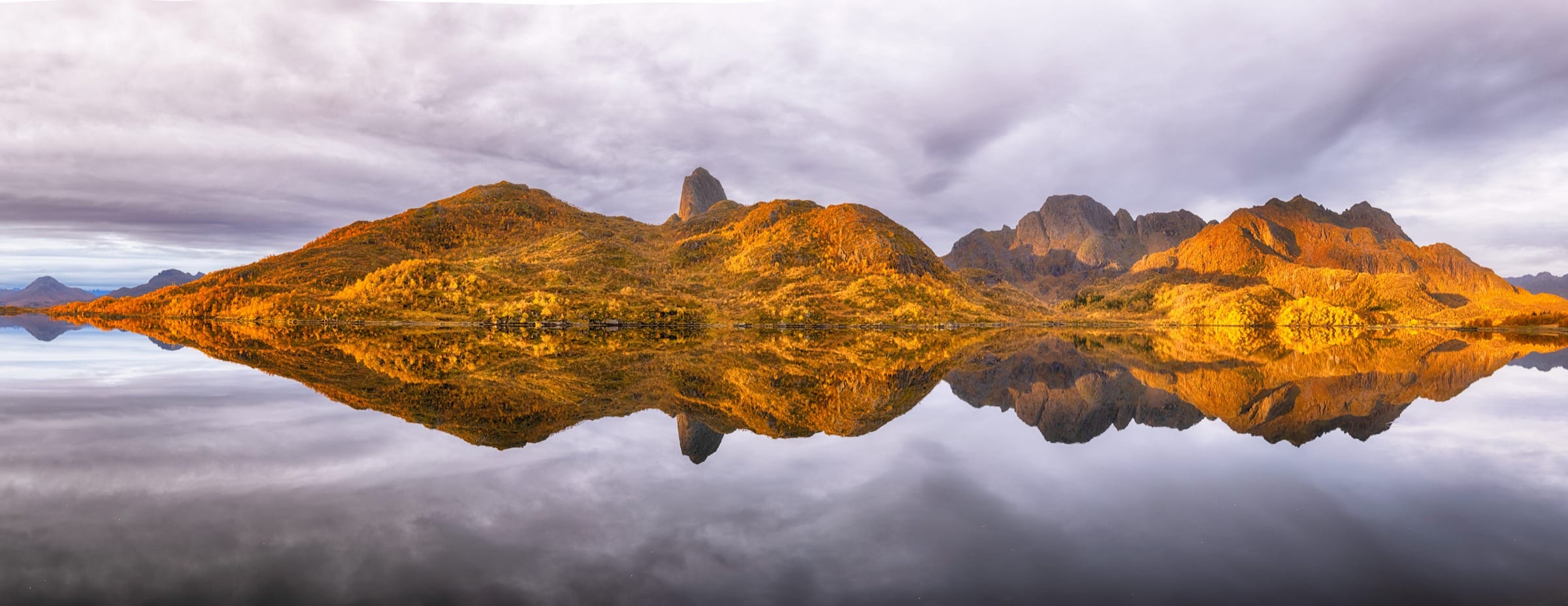 Golden autumn mountainsides mirrored in still water, Vesterålen