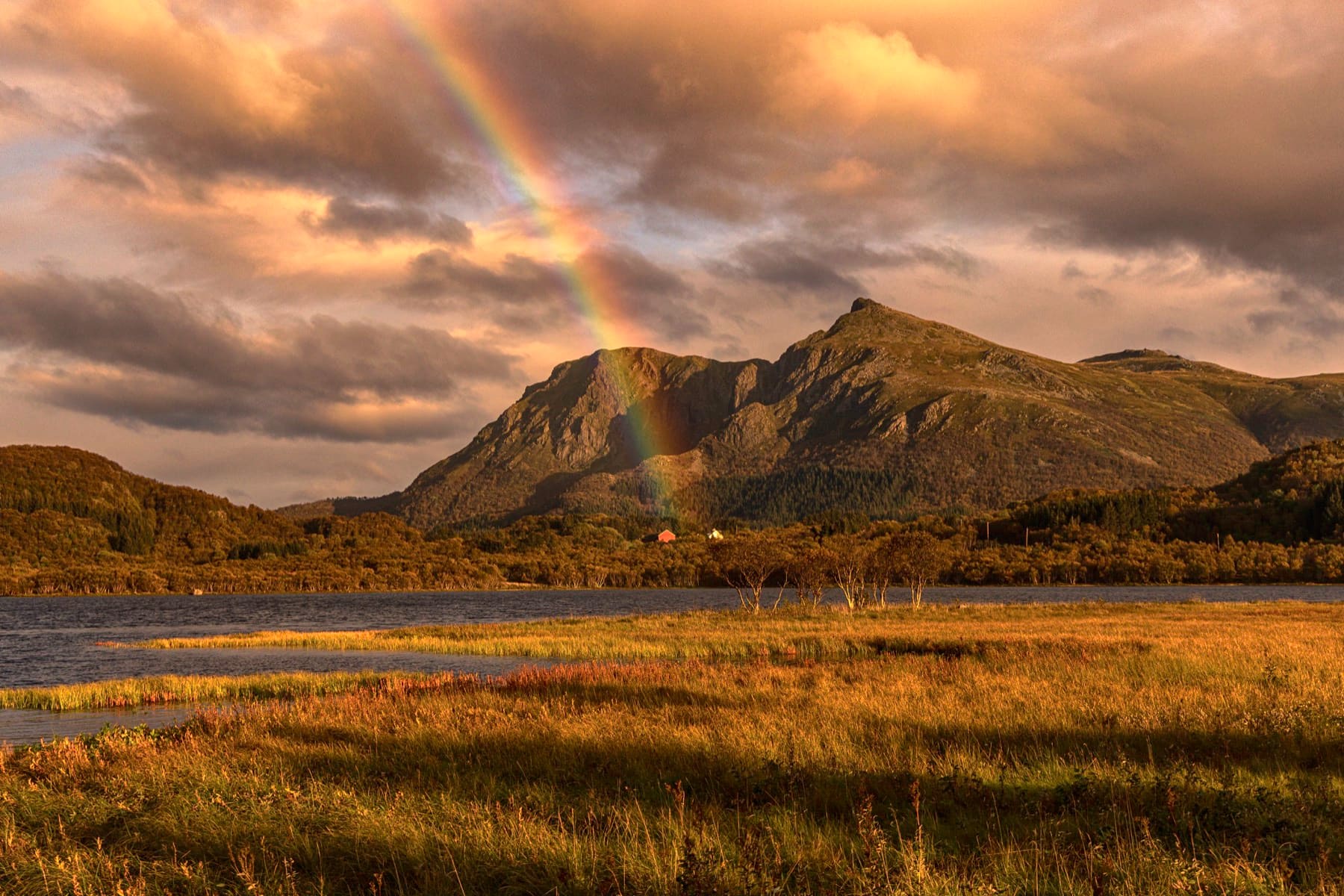 Rainbow over a mountain ridge in low golden evening light, Vesterålen